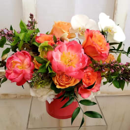Bright bouquet of pink and orange flowers in a red container
