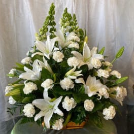 White lilies and carnations arranged in a basket