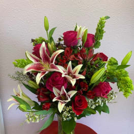 Bouquet of red roses and white lilies in a clear glass vase
