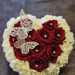 Heart-shaped bouquet of red roses and white carnations with butterfly decorations