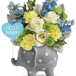 Blue, yellow, and white bouquet in a gray elephant planter with a "Hello Baby!" sign