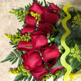 Bouquet of red roses wrapped in clear plastic with yellow ribbon