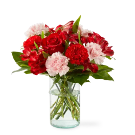 Red roses and pink carnations in a clear glass vase