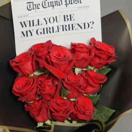 Bouquet of red roses with a newspaper-style proposal card