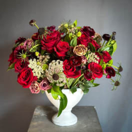 Red rose bouquet in a white pedestal vase
