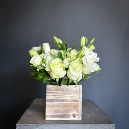 White roses and lisianthus in a wooden box