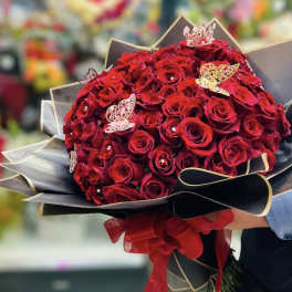 Bouquet of red roses with black wrapping and butterfly decorations
