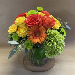 Bouquet of red, yellow, and orange flowers in a glass vase