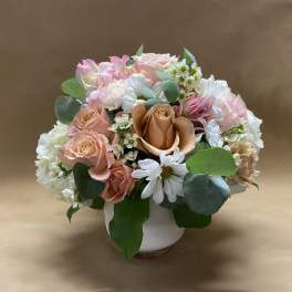 Pink and white flower arrangement in a white vase