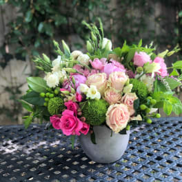 Pink and cream roses in a gray vase with green accents