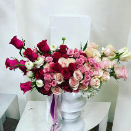 Bouquet of pink and red roses in a white pedestal vase
