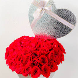 Heart-shaped box of red roses with a silver heart topper and ribbon