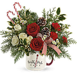 Christmas bouquet of red and white roses in a mug with candy canes and pinecones