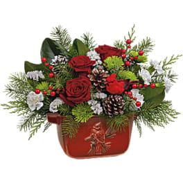 Red roses in a red holiday container with pinecones and evergreen accents