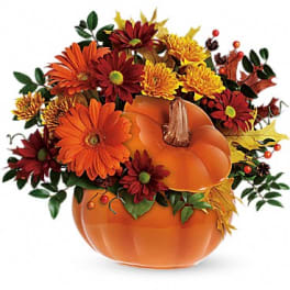Pumpkin-shaped arrangement with orange and red flowers