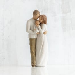 Wooden figurine of a couple holding a baby