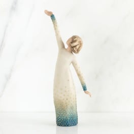 Decorative figurine of a woman in a long dress with one arm raised