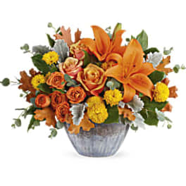 Orange lilies and roses in a silver vase