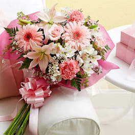 Pink and white mixed bouquet wrapped in pink paper with a ribbon