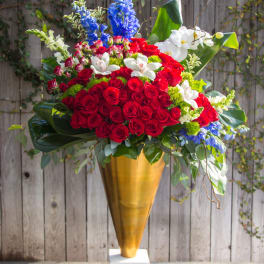 Large red rose arrangement in a gold vase with white and blue flowers