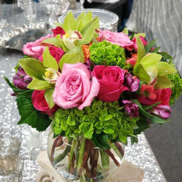 Pink roses and green orchids in a glass vase