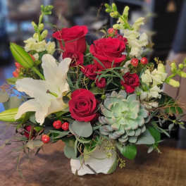 Bouquet of red roses and white lilies with a succulent in a white vase
