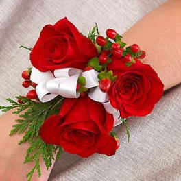 Red rose wrist corsage with white ribbon and berries