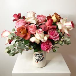 Mixed roses in a white vase with "you are my person" text