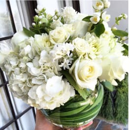White roses and hydrangeas in a clear glass vase