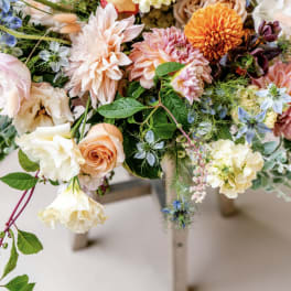 Mixed pastel bouquet with roses, dahlias, and small blue flowers