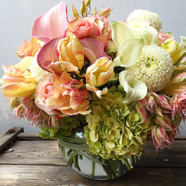 Mixed bouquet of pastel flowers in a glass vase