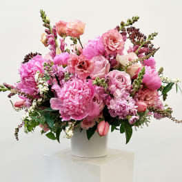 Pink mixed flower arrangement in a white vase