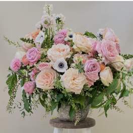 Large pastel bouquet of roses and white anemones in a textured vase