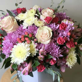 Bouquet of pink roses and purple chrysanthemums in a white box