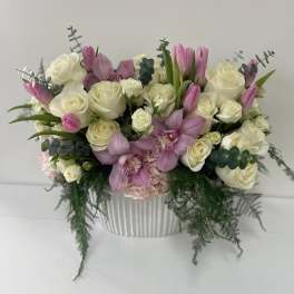 Pink and white floral arrangement in a ribbed white vase
