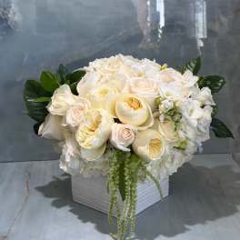 Cream and white floral arrangement in a white square vase