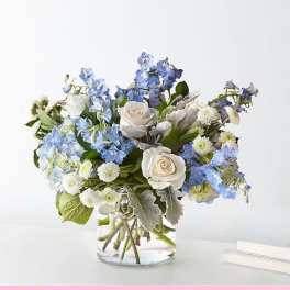 Blue and white flower arrangement in a clear glass vase