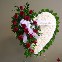 Heart-shaped funeral spray with red roses and white flowers