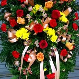 Standing floral spray with red and yellow roses and ribbon streamers
