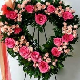 Heart-shaped floral wreath with pink roses and small pale pink blooms
