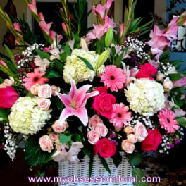Large pink and white floral arrangement in a white basket