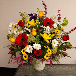 Colorful mixed flower arrangement in a white vase