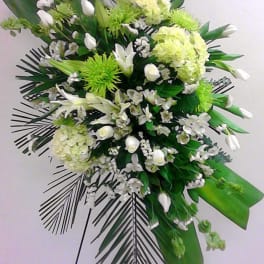 Standing floral spray with white and green flowers on an easel