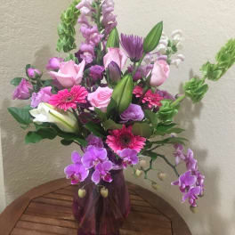 Bouquet of pink and purple flowers in a purple glass vase