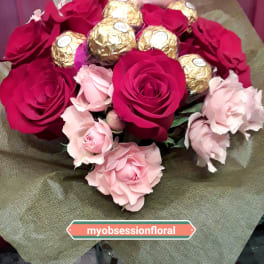 Bouquet of red and pink roses with gold-wrapped chocolates