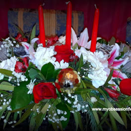 Red and white floral centerpiece with tall red candles