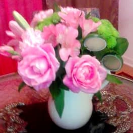 Pink floral bouquet in a white vase with green accents