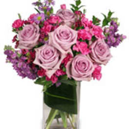 Pink and lavender roses in a clear glass vase