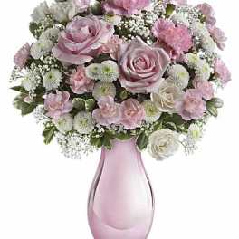 Pink and white rose bouquet in a pink glass vase