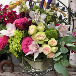 Mixed bouquet in a glass vase with pink, white, green, and purple flowers